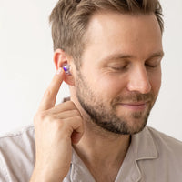 Purple-05 | High-Fidelity Washable Silicone Ear Plugs, worn, fingertip closeup