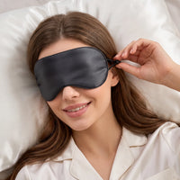 black | Ice Silk Cooling & Warming Sleep Mask, worn in bed, adjusting the strap